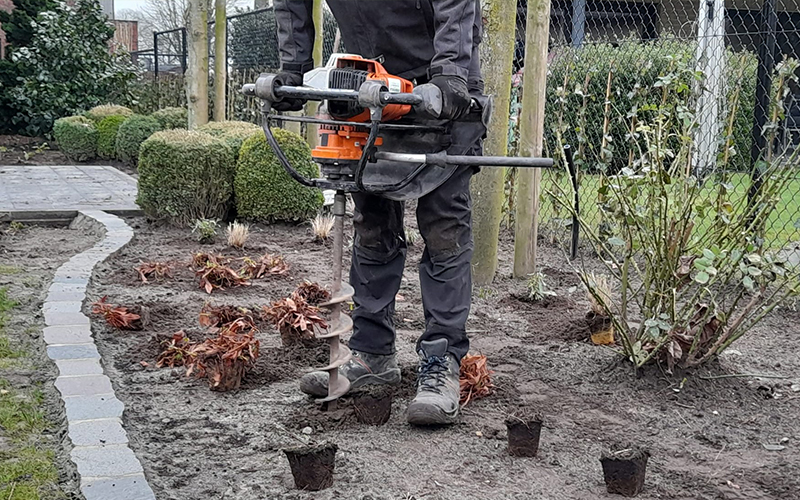 Tuinman van Tuinaanleg Damen uit Loenhout gebruikt grondboor bij aanplanting