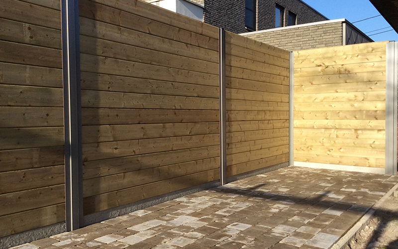 Nieuwe houten omheining met betonbalken en terras bij tuinrenovatie project in Hoogstraten